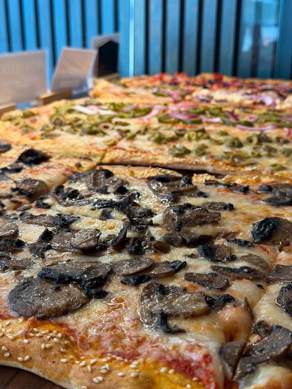 A tray of pizza al taglio with mushrooms and truffle